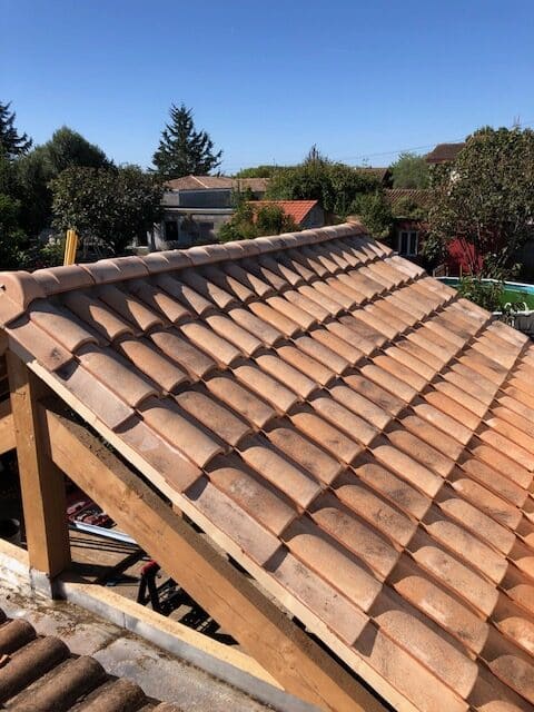 Rénovation Toiture : Pose de Tuiles Canal Traditionnelles Pose de tuiles canal sur une charpente bois traditionnelle lors d'une rénovation de toiture.